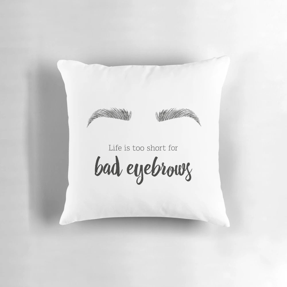 A decorative throw pillow featuring a minimalist illustration of a woman's face and stylized eyebrows.