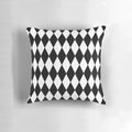 A black and white harlequin pattern pillow with a classic diamond design.