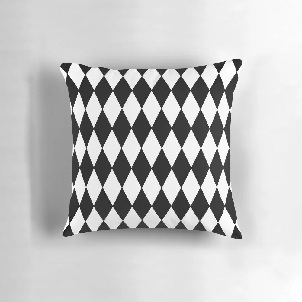 A black and white harlequin pattern pillow with a classic diamond design.