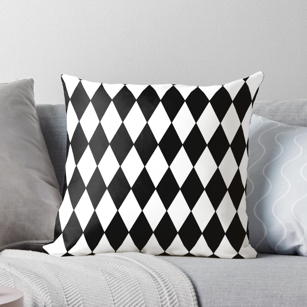 A black and white harlequin pattern pillow with a classic diamond design.