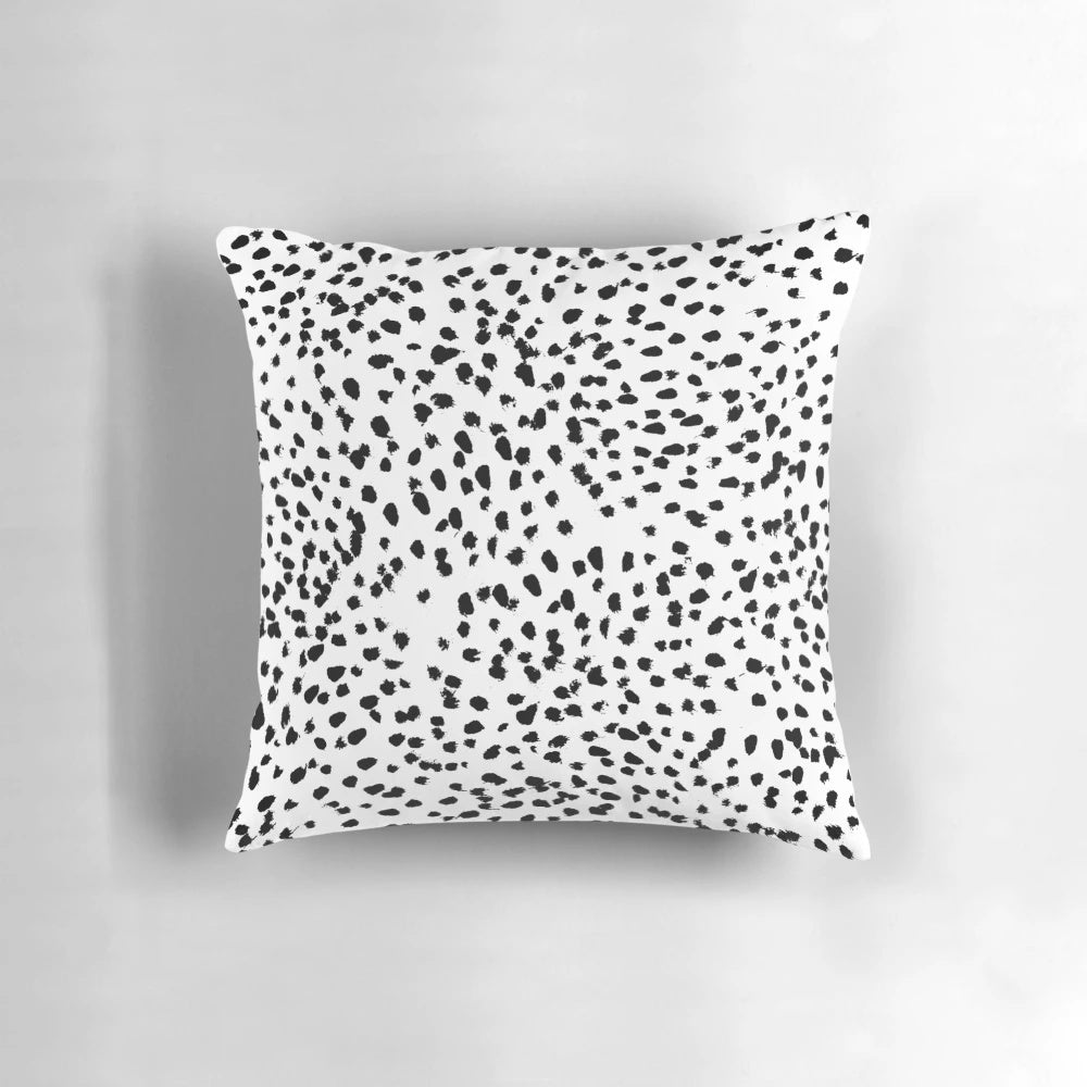 A black and white pillow featuring a minimalist animal print pattern.