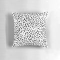 A black and white pillow featuring a minimalist animal print pattern.