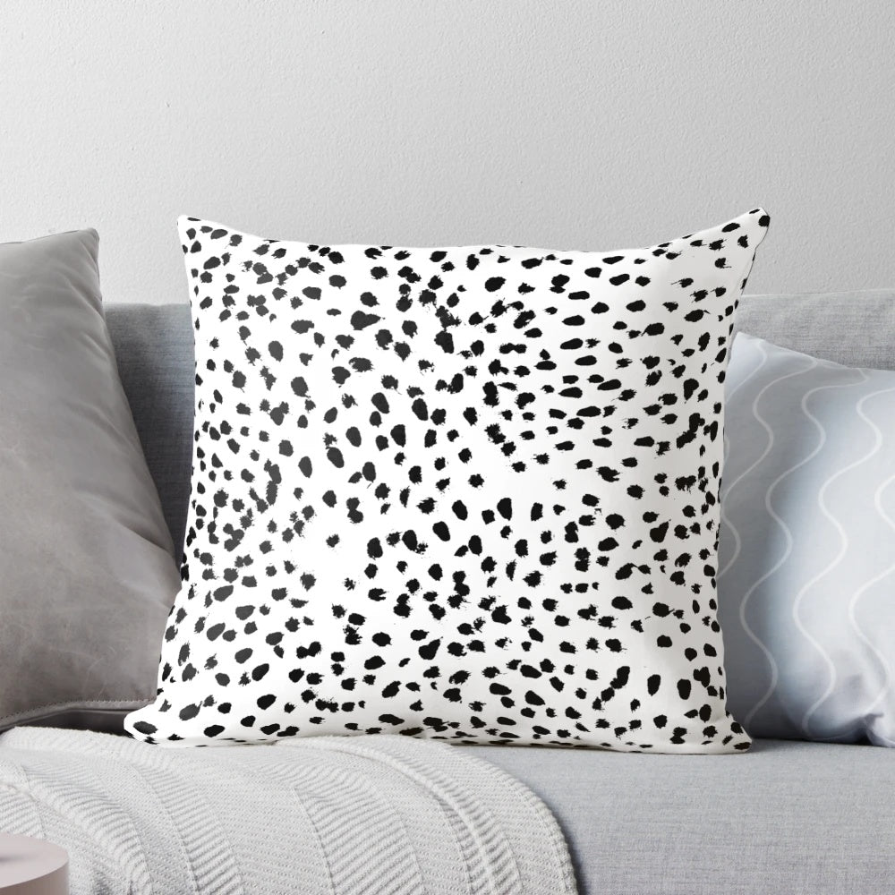 A black and white pillow featuring a minimalist animal print pattern.