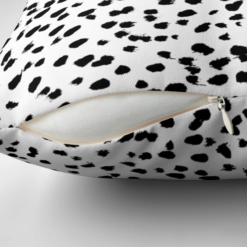 A black and white pillow featuring a minimalist animal print pattern.
