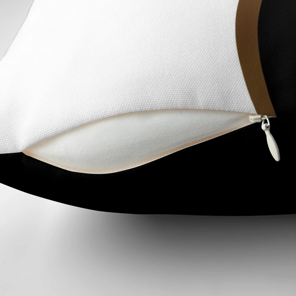 Closeup of a black and white decorative pillow with a bold gold wave pattern.