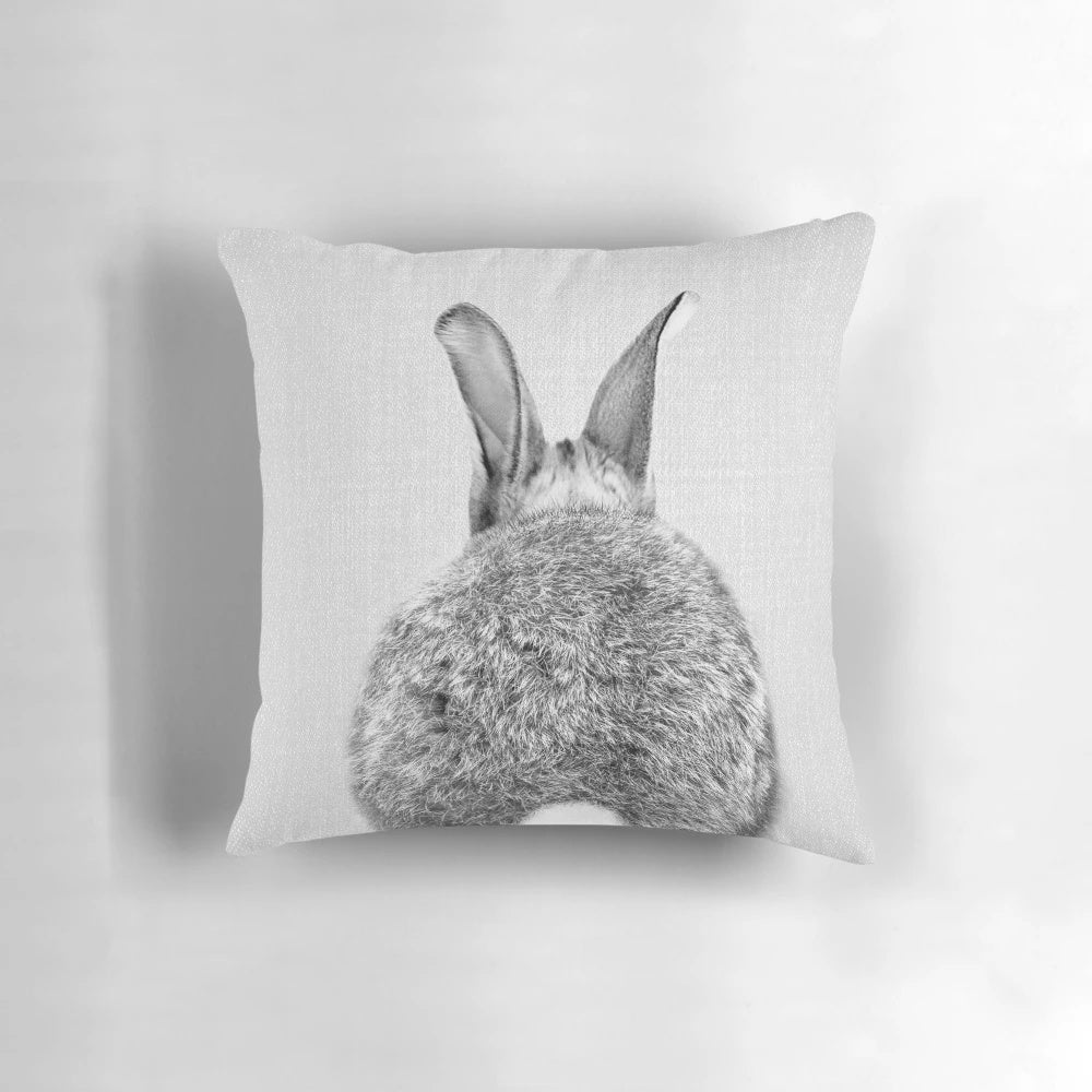A modern black and white throw pillow featuring a playful rabbit tail design.