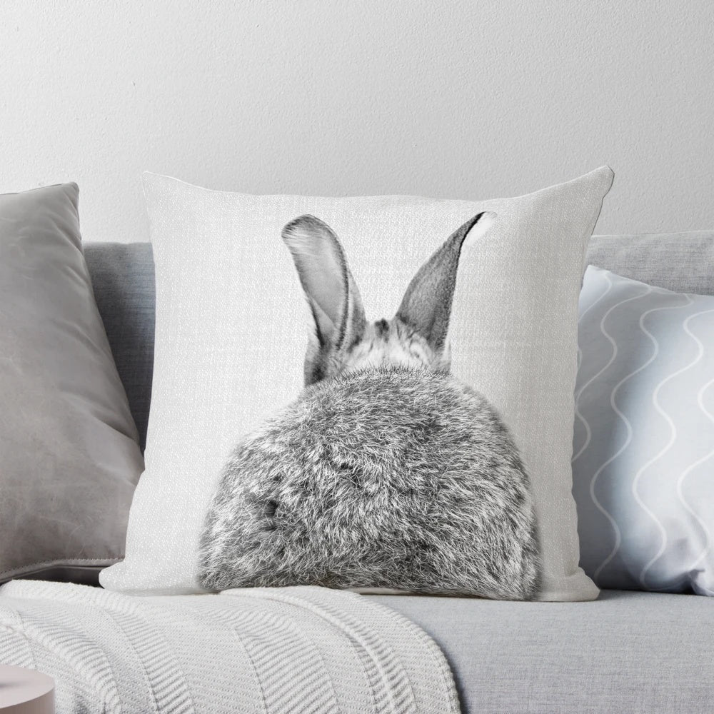 A modern black and white throw pillow featuring a playful rabbit tail design.