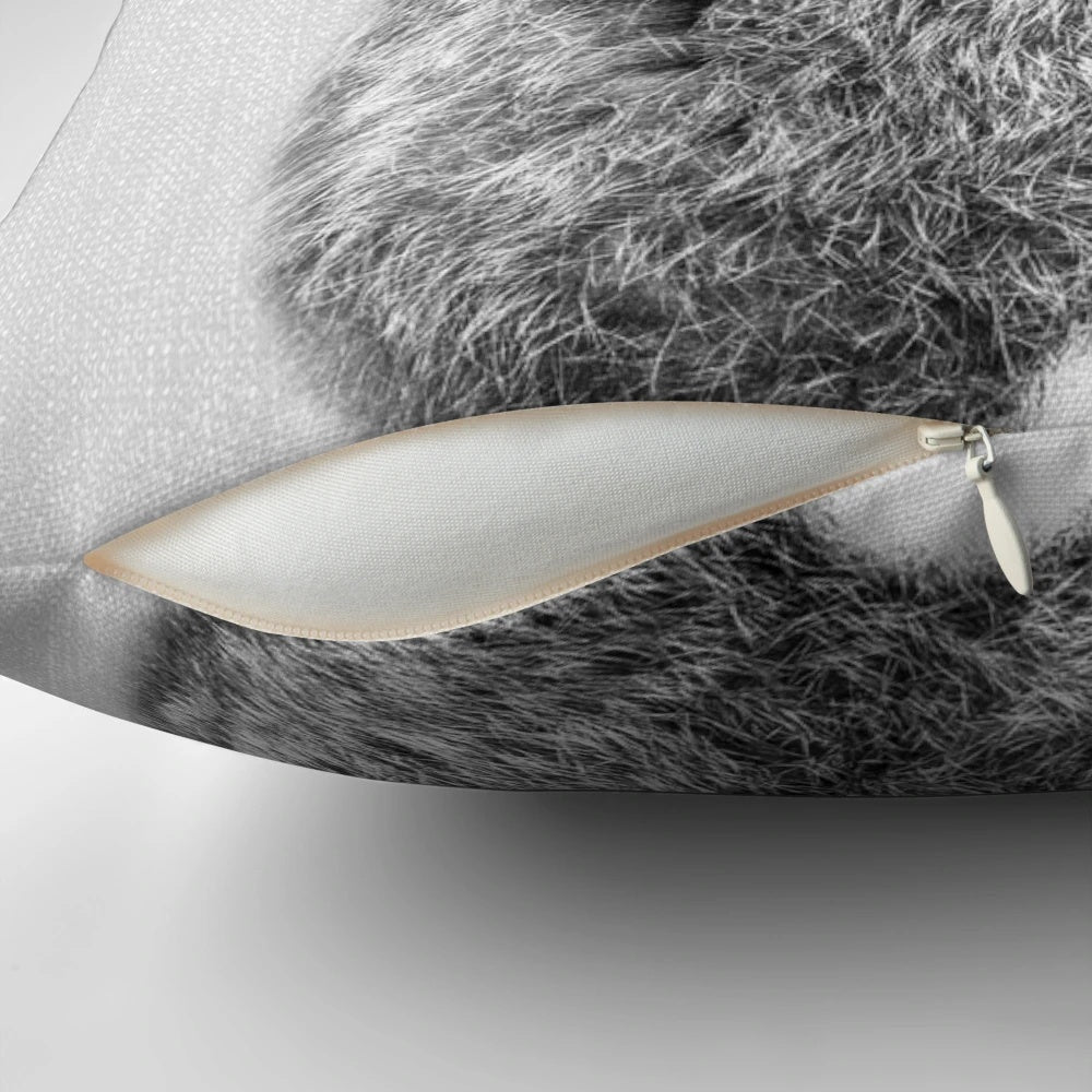 A modern black and white throw pillow featuring a playful rabbit tail design.
