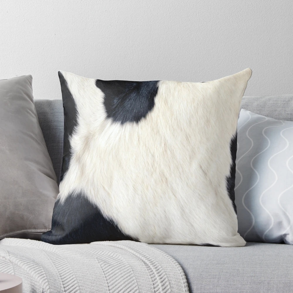 A black and white pillow with a faux cowhide pattern, creating a natural and textured look.