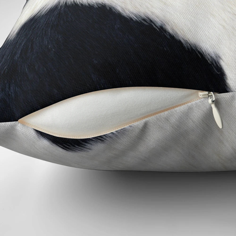 A black and white pillow with a faux cowhide pattern, creating a natural and textured look.