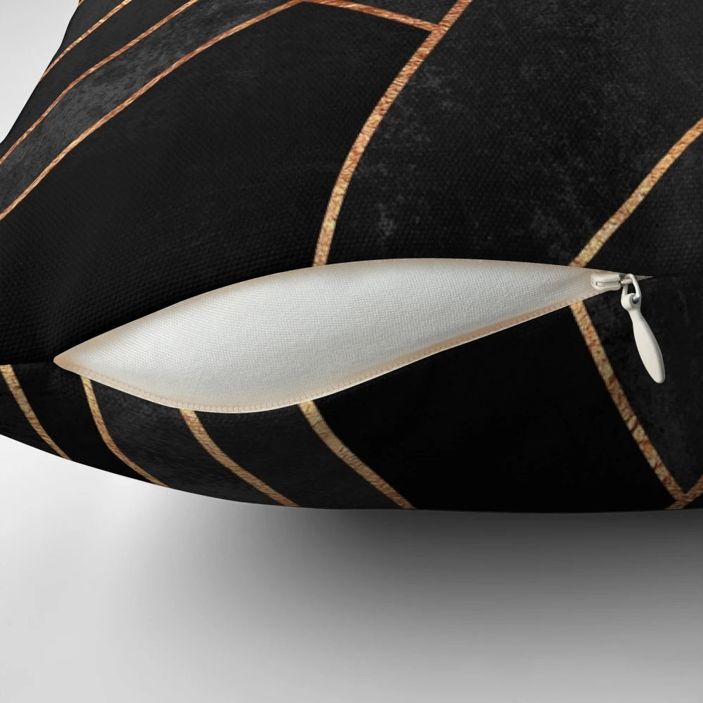 Black and copper geometric pattern pillow with abstract lines and shapes