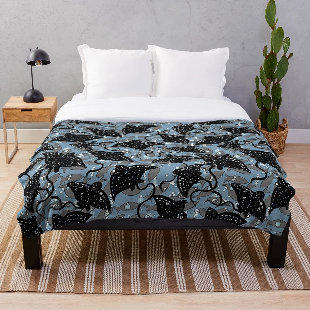 Black spotted eagle ray plush blanket with a school of fish pattern