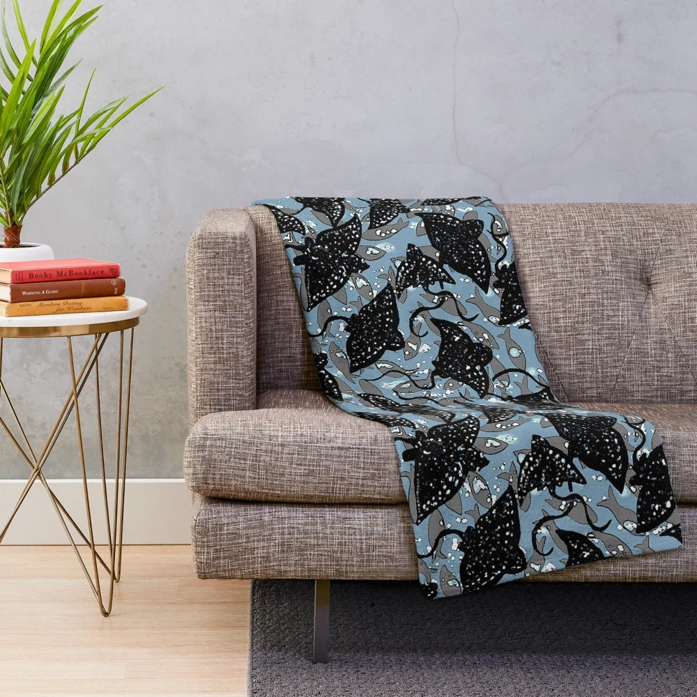 Black spotted eagle ray plush blanket with a school of fish pattern