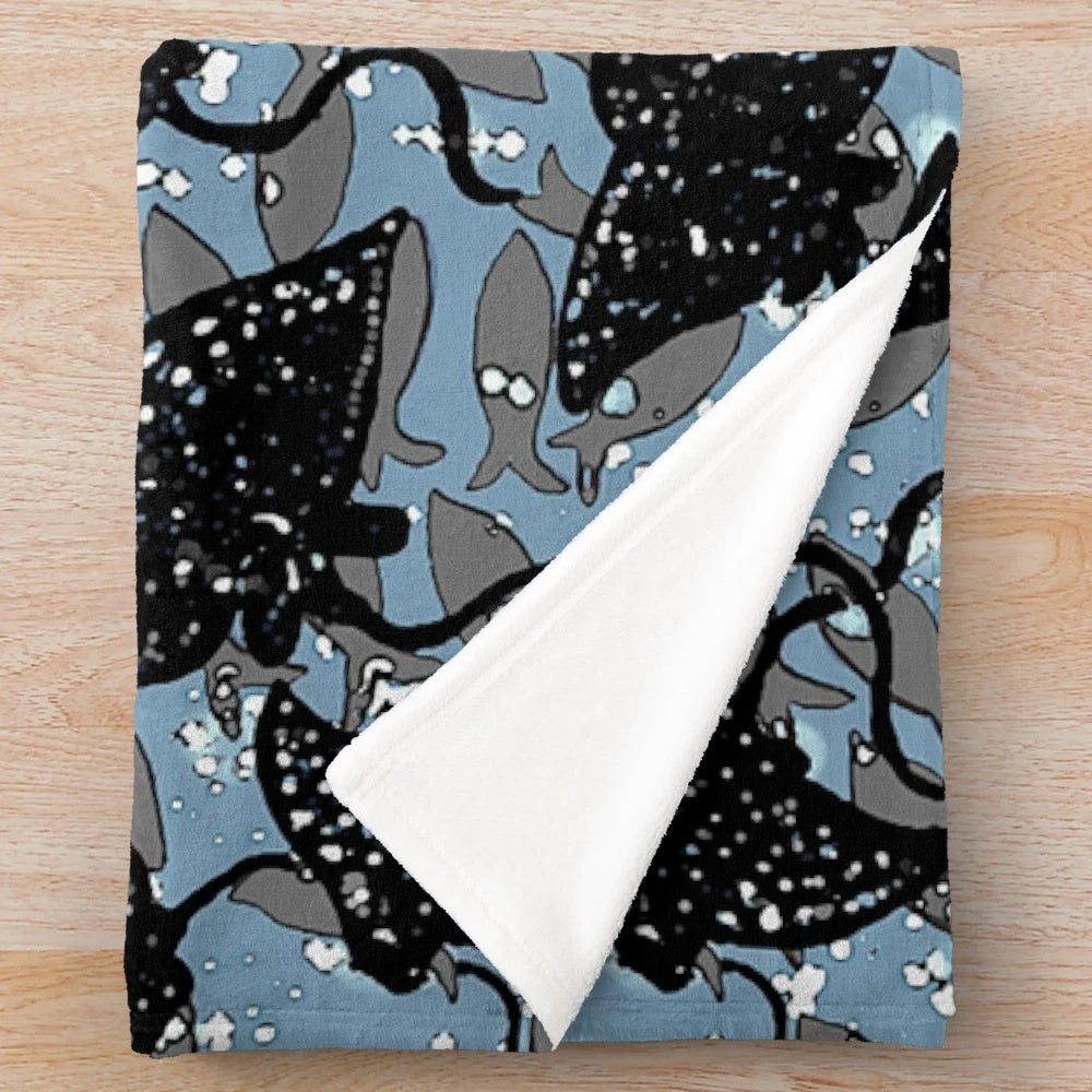 Black spotted eagle ray plush blanket with a school of fish pattern