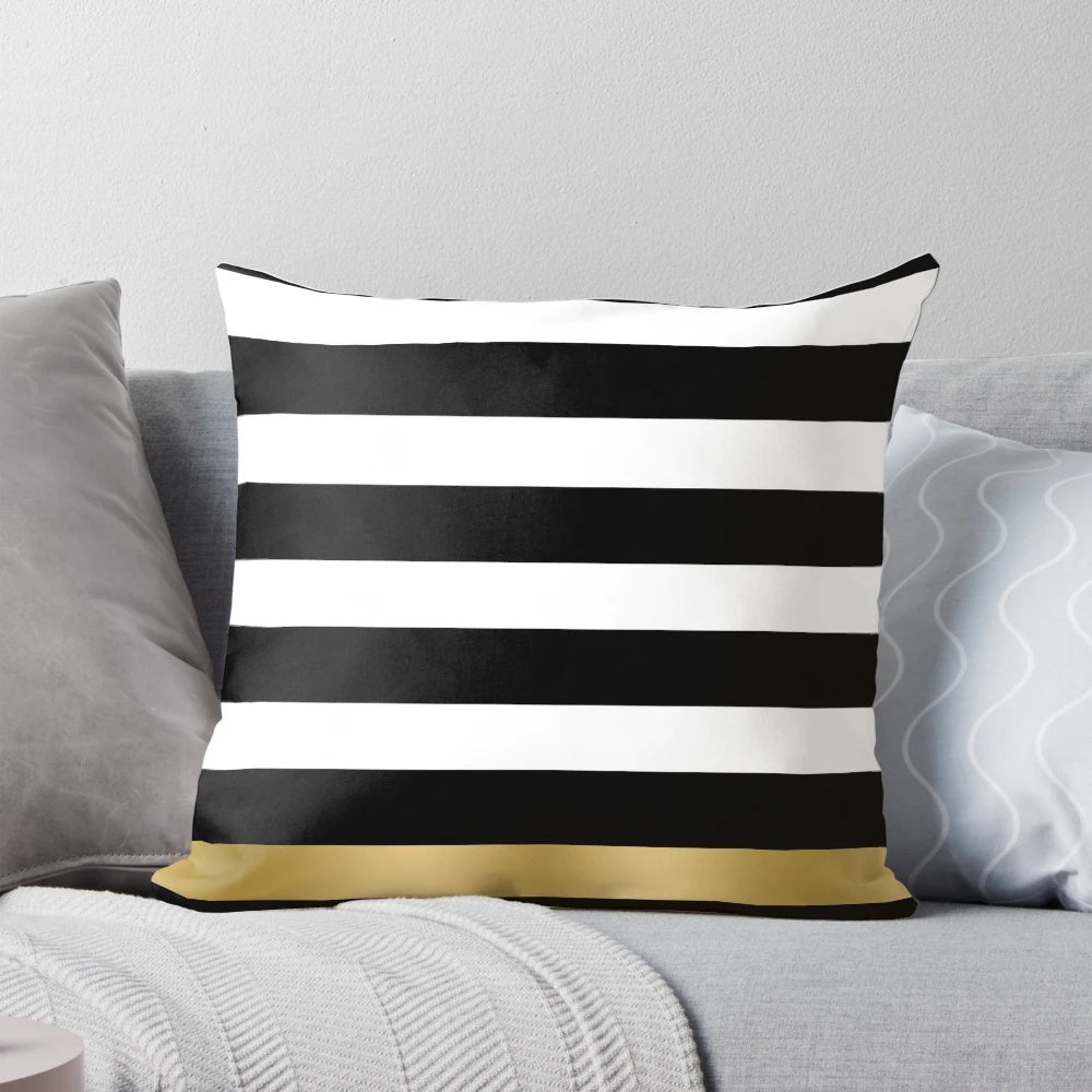 Black, white and gold striped decorative throw pillow with a modern geometric pattern