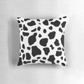 Cow print pillow with a neutral color scheme and soft texture