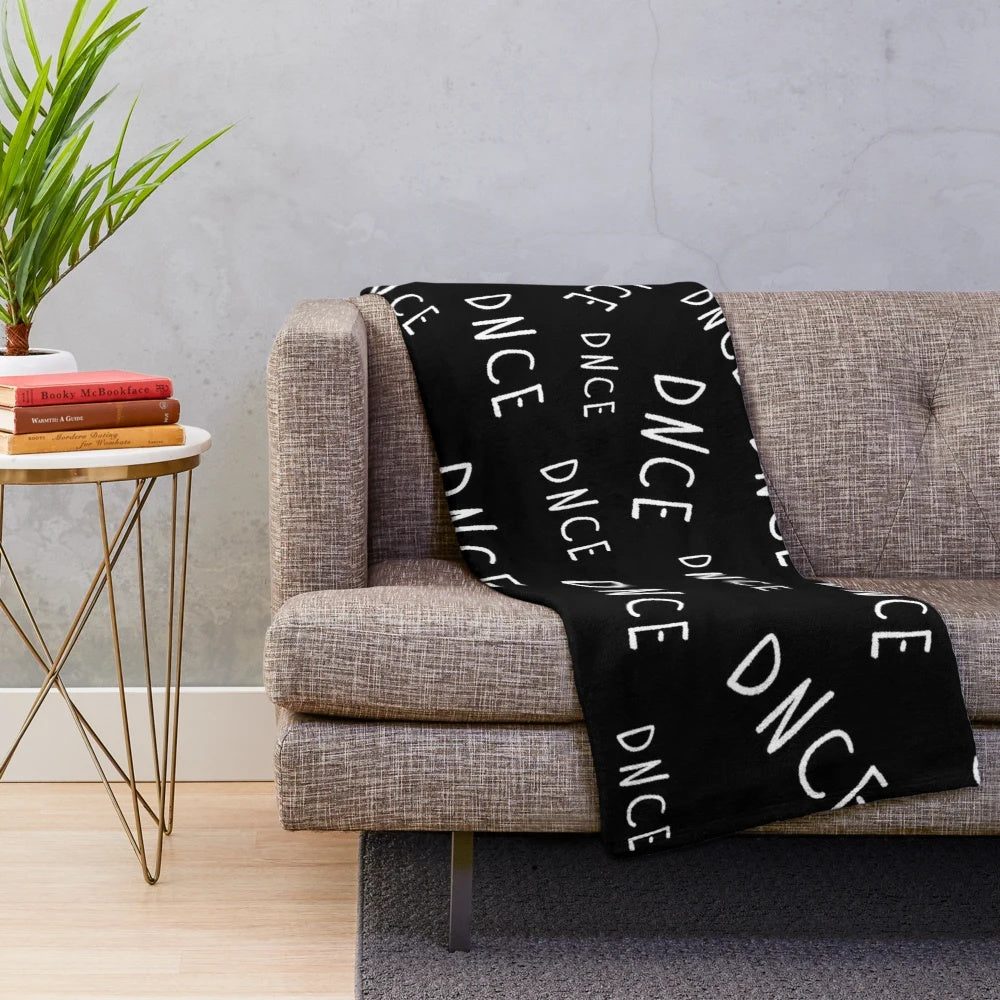 DNCE logo printed on a soft, black and white plush blanket