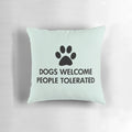 A cozy black pillow with the text "Dogs Welcome, People Tolerated" and a dog paw print design.