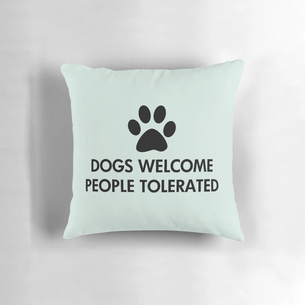 A cozy black pillow with the text "Dogs Welcome, People Tolerated" and a dog paw print design.
