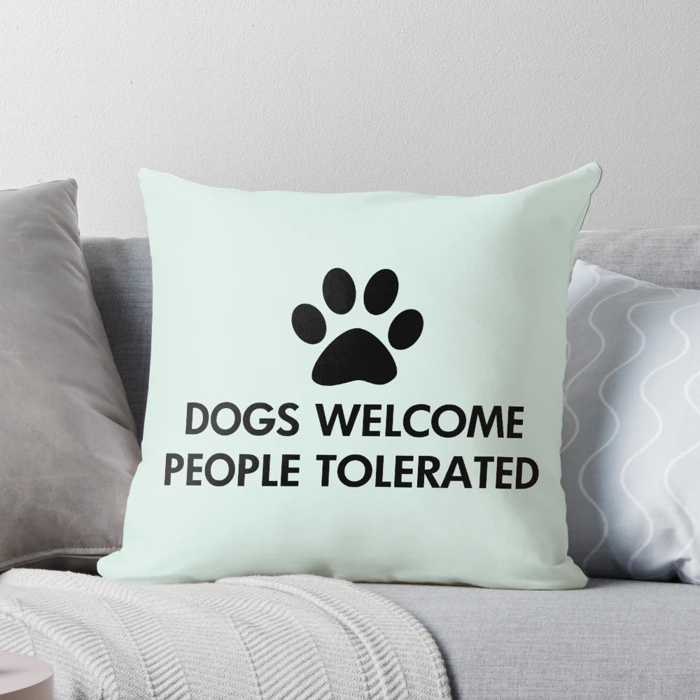 A cozy black pillow with the text "Dogs Welcome, People Tolerated" and a dog paw print design.