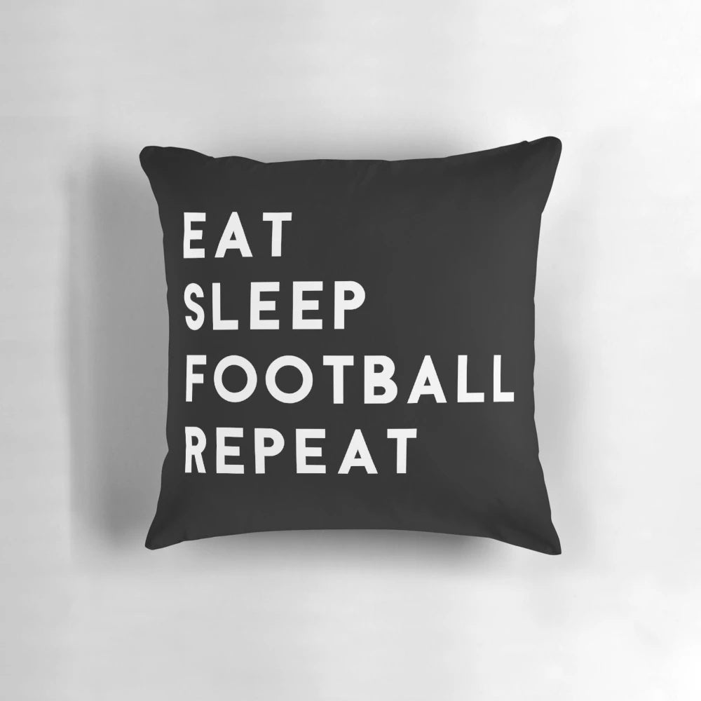 A white pillow with the text "Eat Sleep Football Repeat" in a bold, modern font