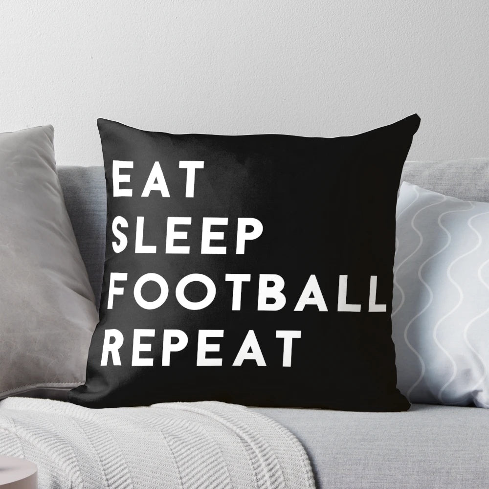 A white pillow with the text "Eat Sleep Football Repeat" in a bold, modern font