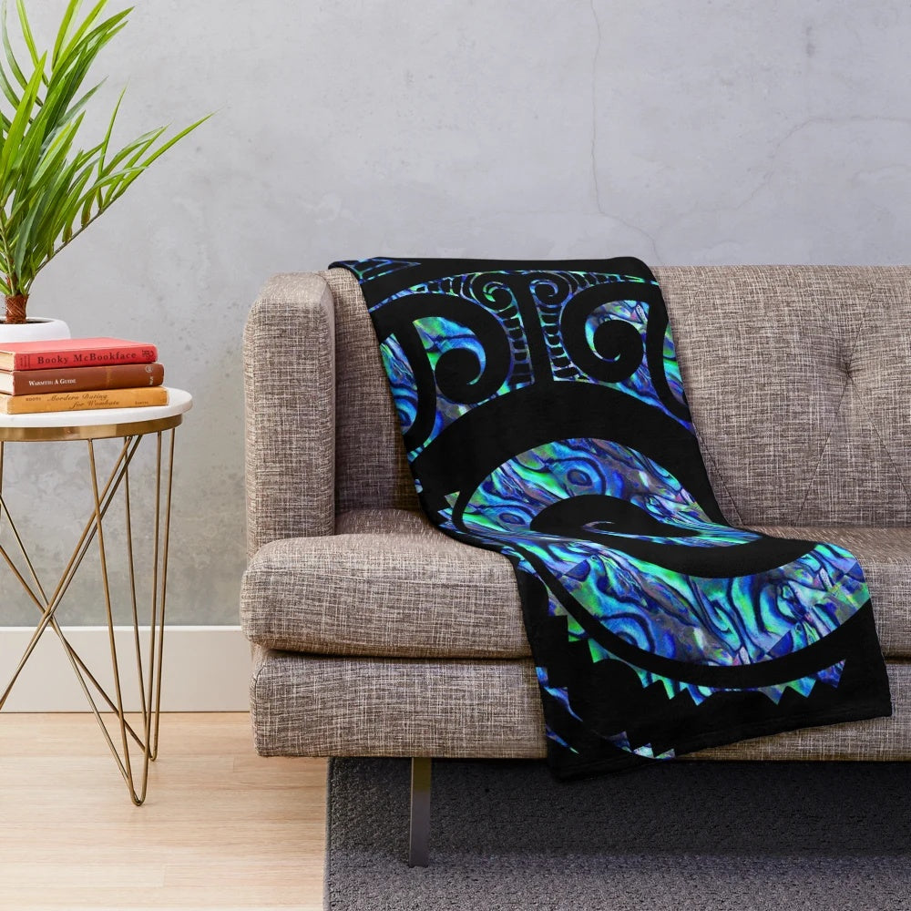 Plush blanket with a Maori-inspired paua tattoo koru design