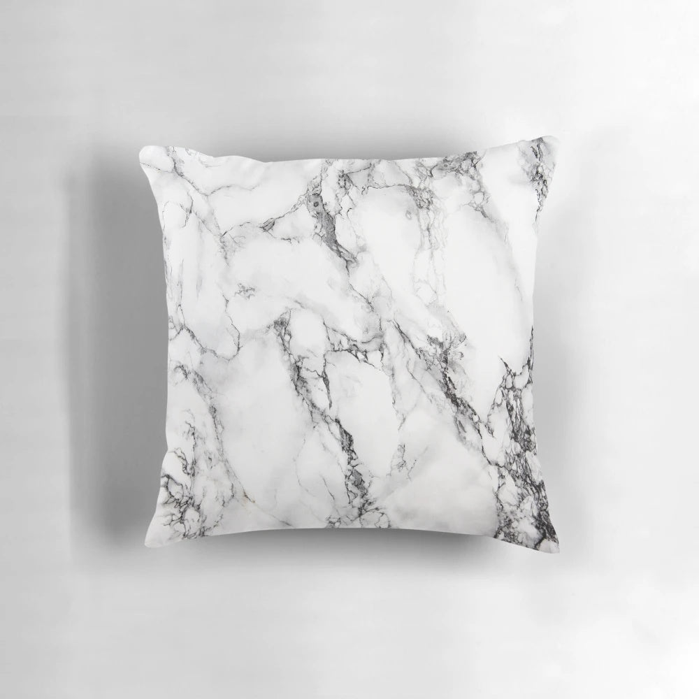 A modern, minimalist marble pattern design on a white pillow and phone case.