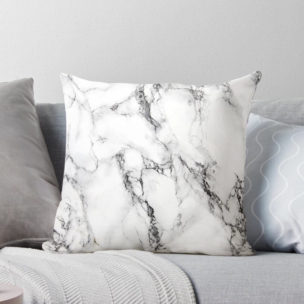 A modern, minimalist marble pattern design on a white pillow and phone case.