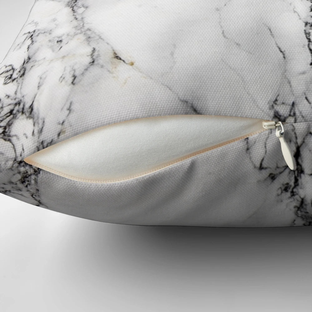 A modern, minimalist marble pattern design on a white pillow and phone case.