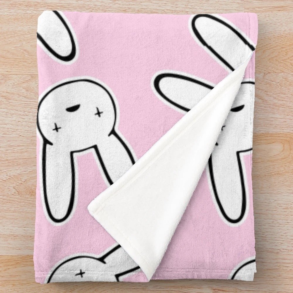 Millennial pink plush blanket featuring the iconic cross-eyed rabbit design from Bad Bunny's Oasis logo