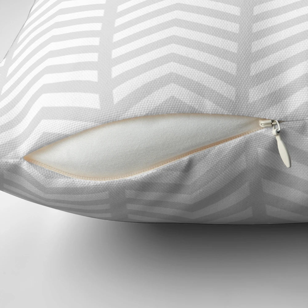Stylish minimalist decorative pillow with a grey and white geometric chevron pattern