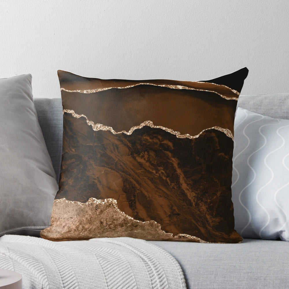 A modern abstract decorative pillow with a minimalist geode design in shades of brown and gold.