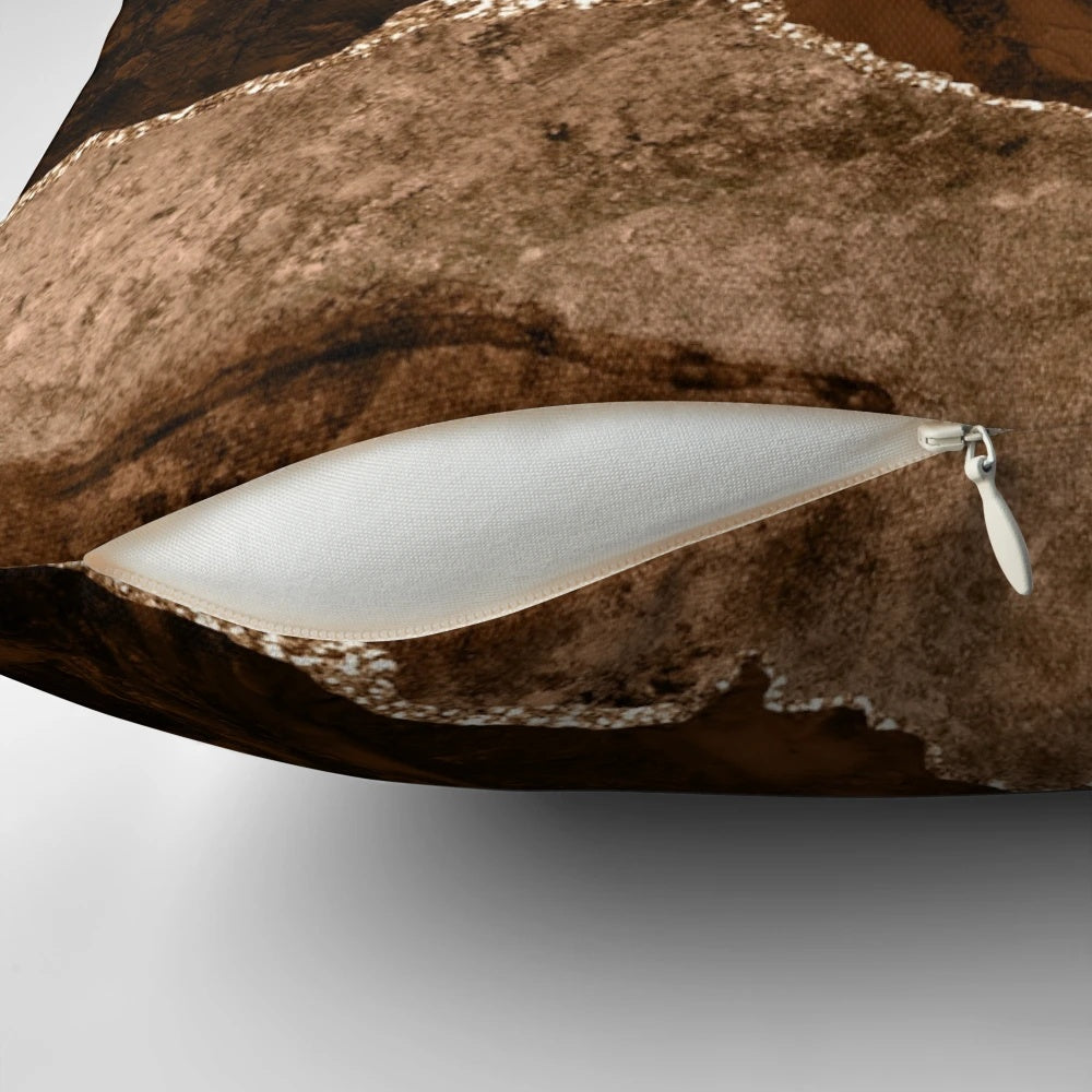 A modern abstract decorative pillow with a minimalist geode design in shades of brown and gold.