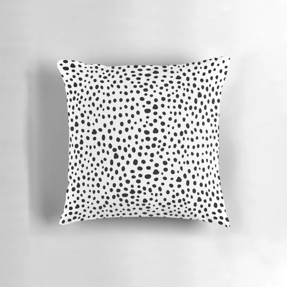A modern, minimalist black and white hand-drawn polka dot pillow, perfect for a sophisticated and chic home decor.