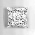 A modern, minimalist black and white hand-drawn polka dot pillow, perfect for a sophisticated and chic home decor.