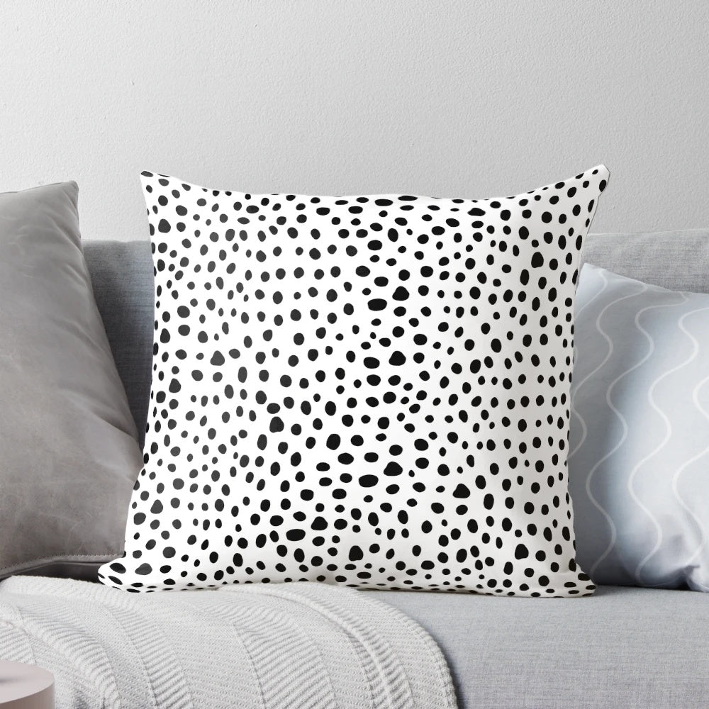 A modern, minimalist black and white hand-drawn polka dot pillow, perfect for a sophisticated and chic home decor.