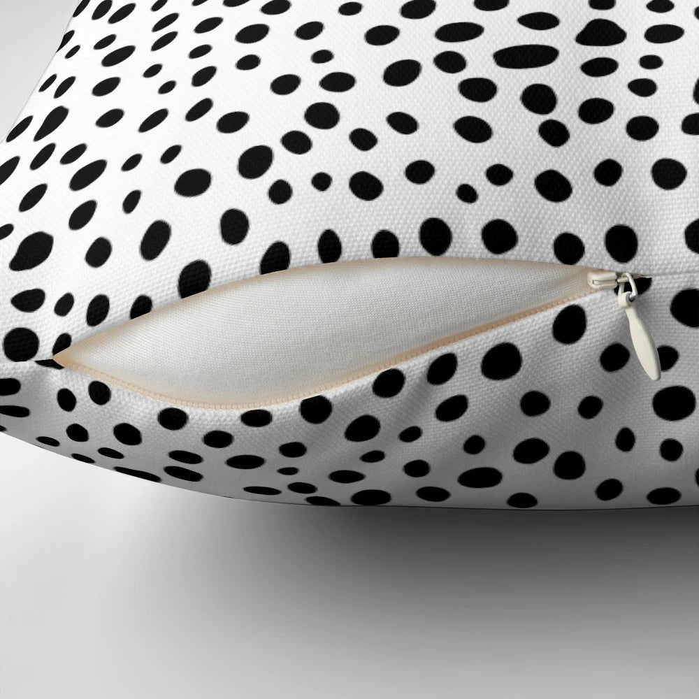 A modern, minimalist black and white hand-drawn polka dot pillow, perfect for a sophisticated and chic home decor.