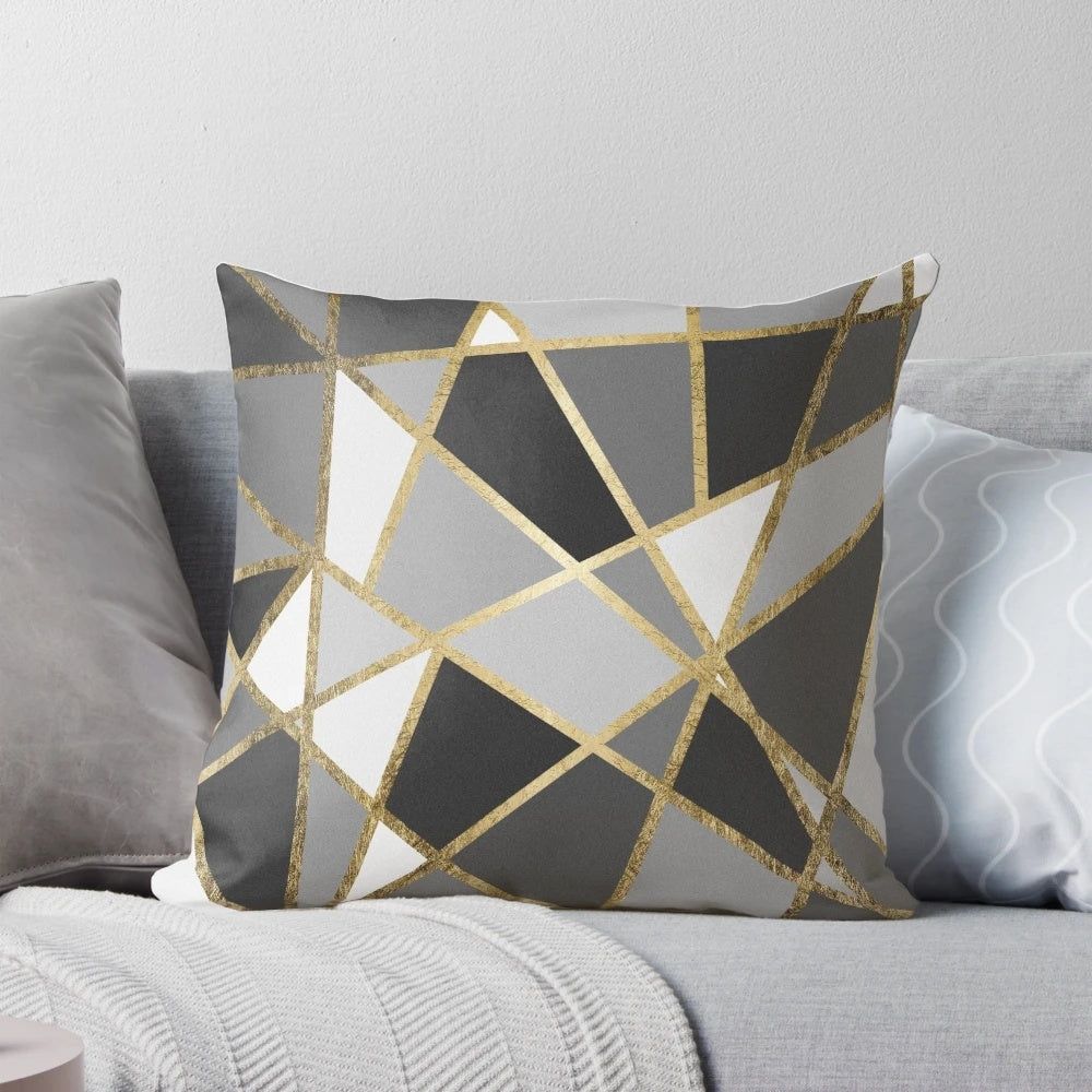 A black and gray modern geometric pillow with gold triangle patterns