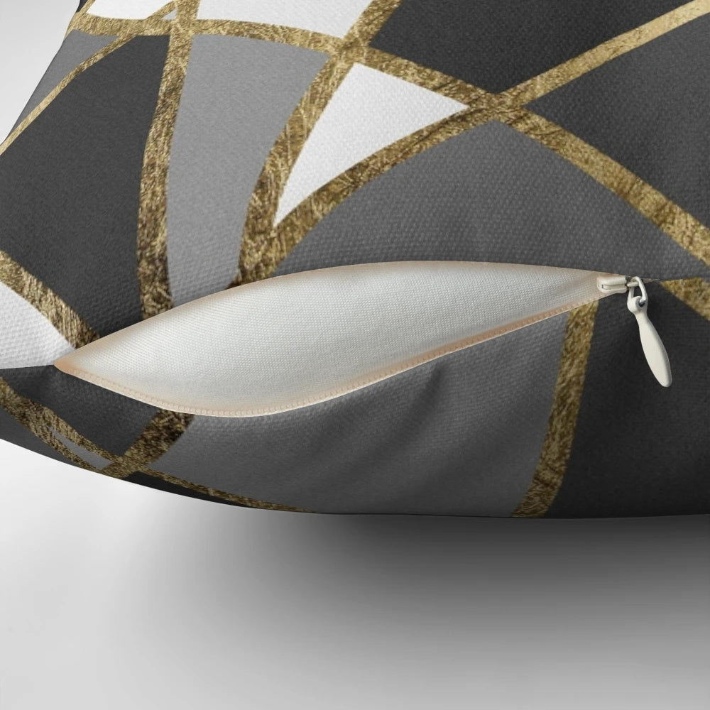 A black and gray modern geometric pillow with gold triangle patterns