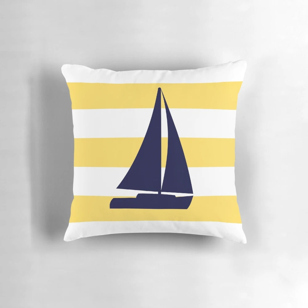 A decorative navy blue and mustard yellow striped pillow with a sailboat design, perfect for coastal or nautical-themed home decor.