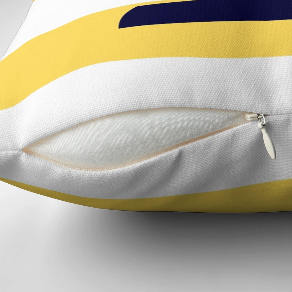 A decorative navy blue and mustard yellow striped pillow with a sailboat design, perfect for coastal or nautical-themed home decor.
