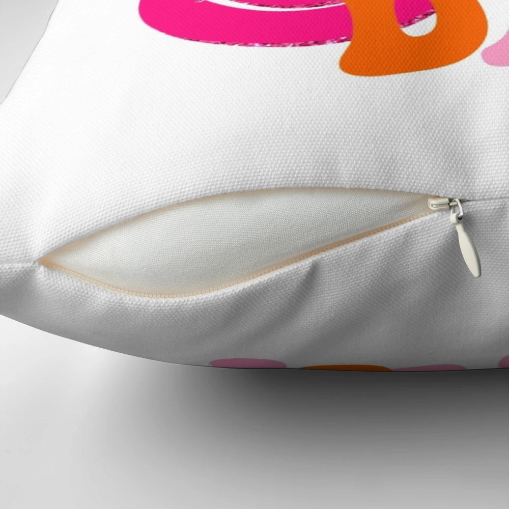 A soft, plush decorative pillow featuring a retro smiley face design in shades of pink and orange, perfect for a preppy, positive aesthetic.