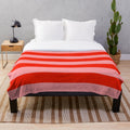 Soft, cozy red and pink striped plush blanket