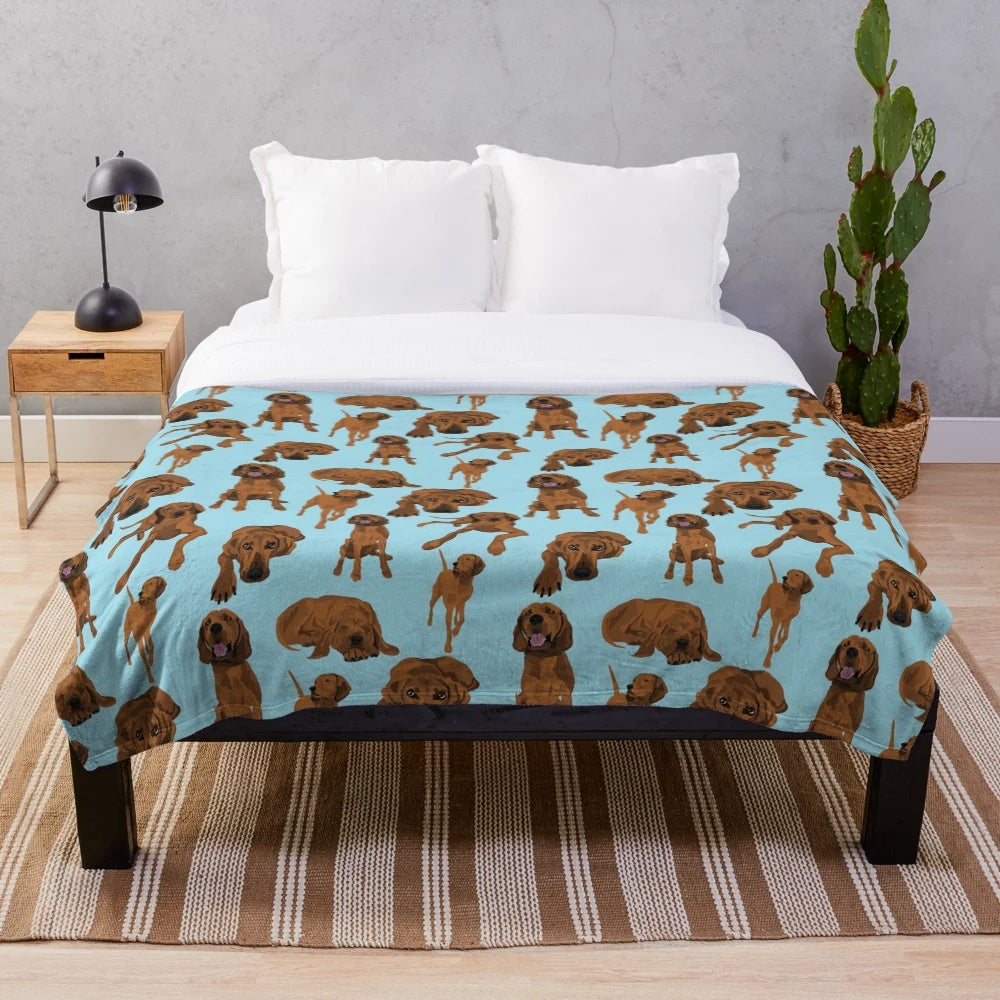 Redbone coonhound on a blue plush blanket with a vibrant dog pattern