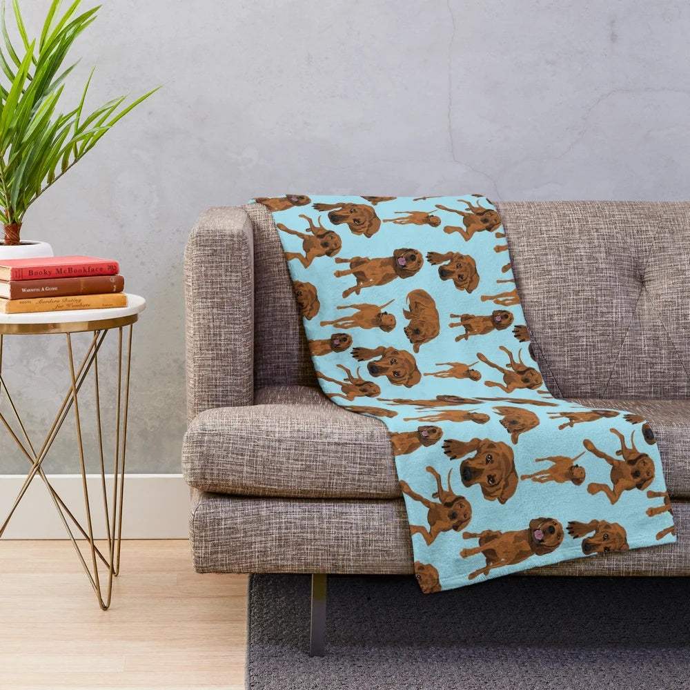 Redbone coonhound on a blue plush blanket with a vibrant dog pattern