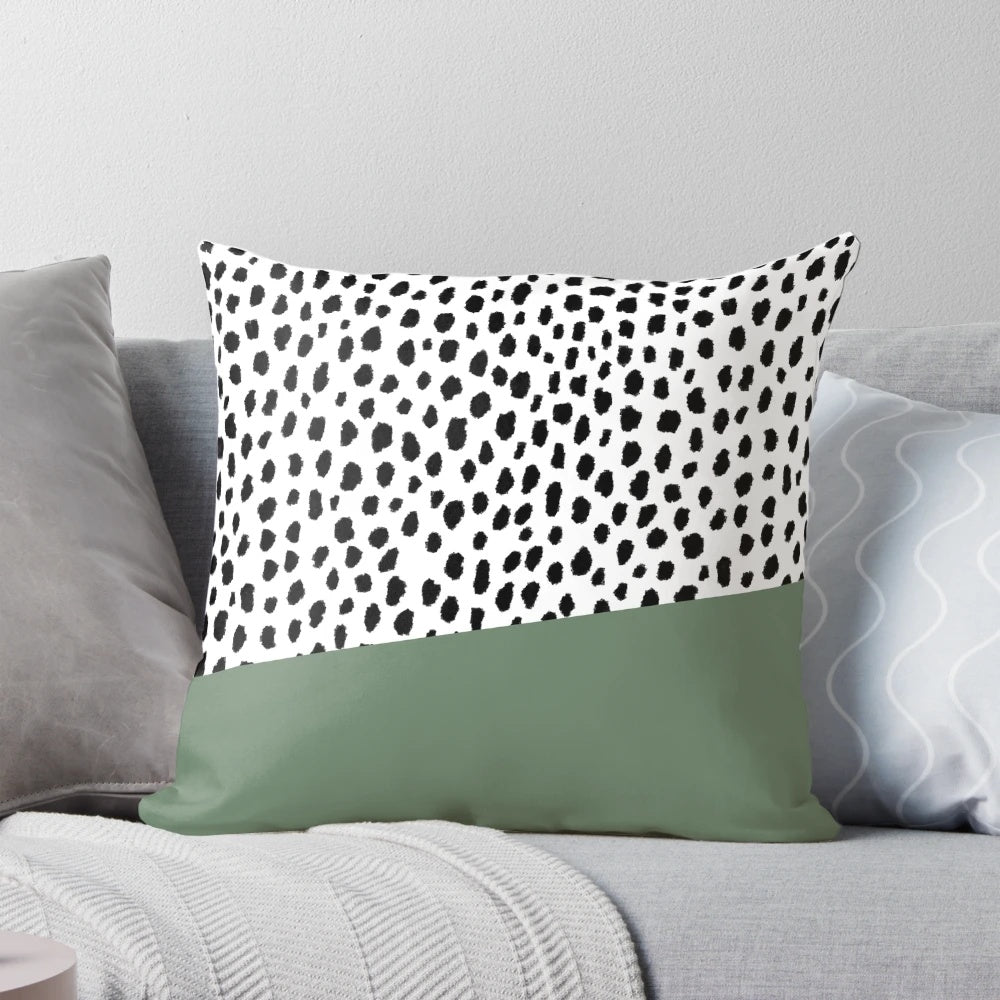Decorative accent pillow featuring a bold dalmatian spots print in shades of sage green, black, and white.