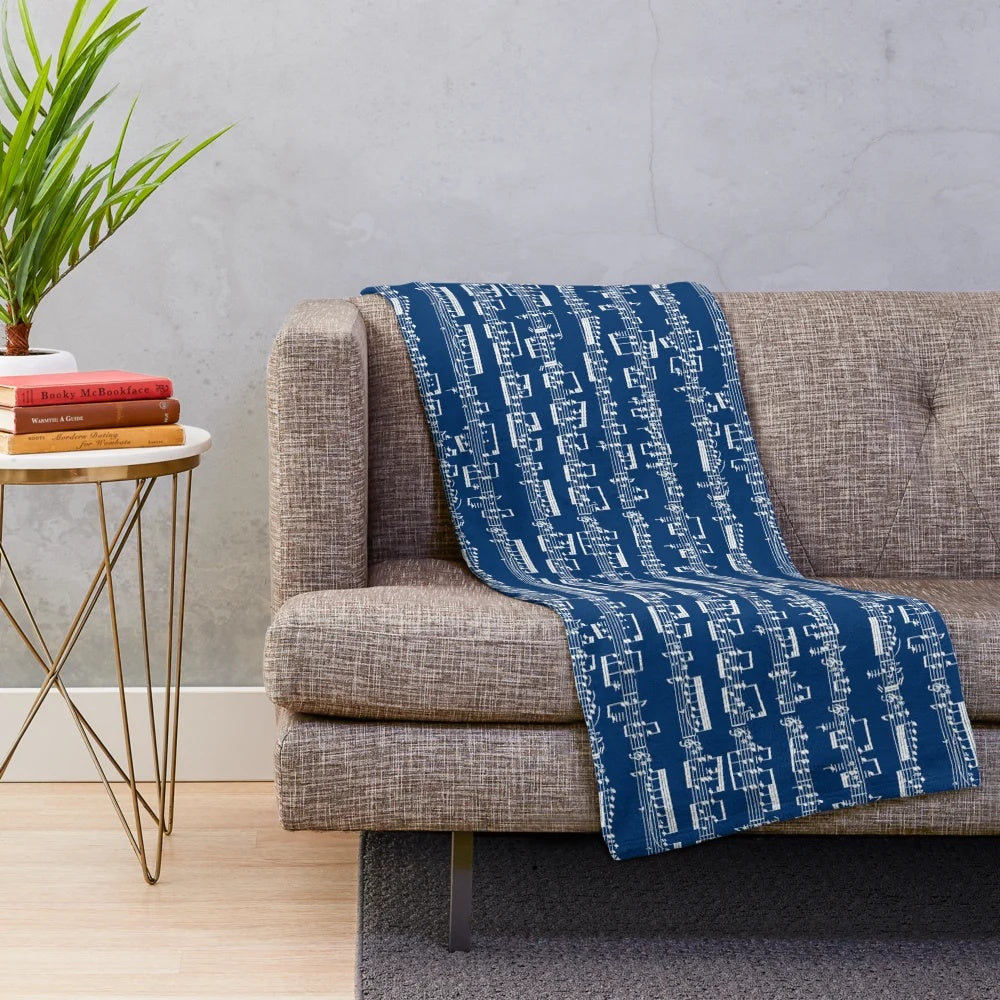 Plush blanket featuring a minimalist black and white sheet music design