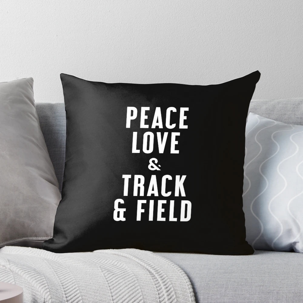 A navy blue pillow with a white graphic design featuring the words "Peace Love and Track & Field
