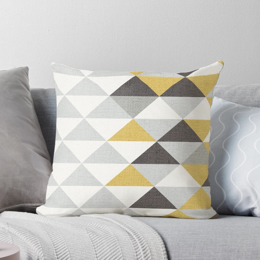 A navy, gray, cream, and yellow triangle pattern textured pillow for modern home decor.